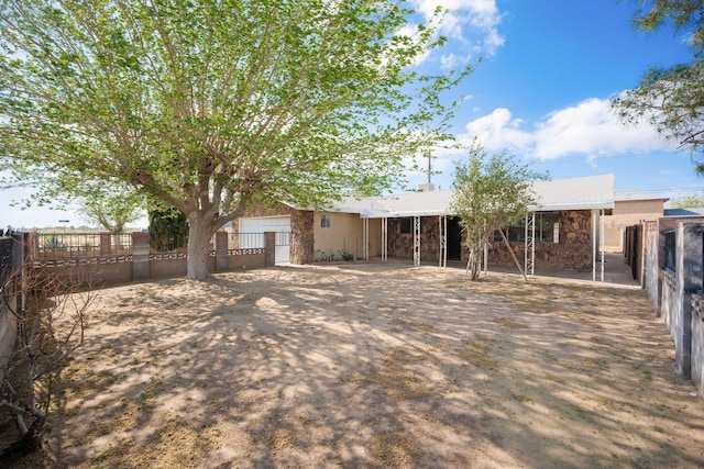 exterior space featuring stucco siding, stone siding, and fence private yard