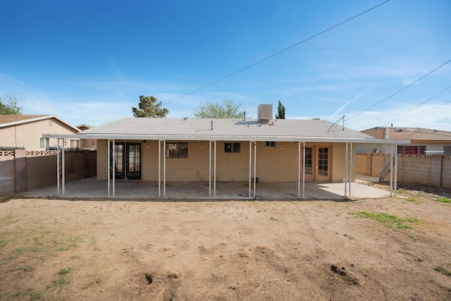 back of house featuring stucco siding, a fenced backyard, french doors, and a patio