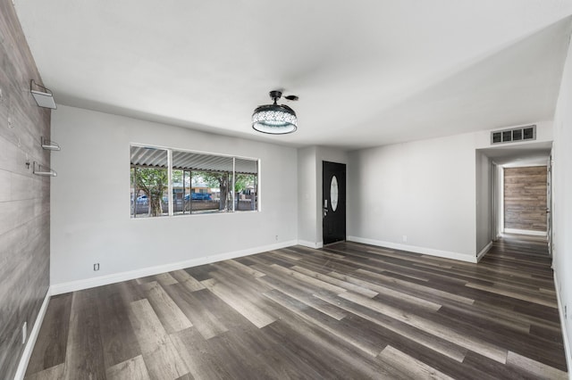 interior space with baseboards, visible vents, and dark wood-style flooring