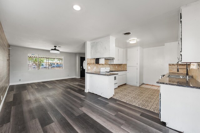 kitchen featuring visible vents, white electric range oven, baseboards, tasteful backsplash, and white cabinetry