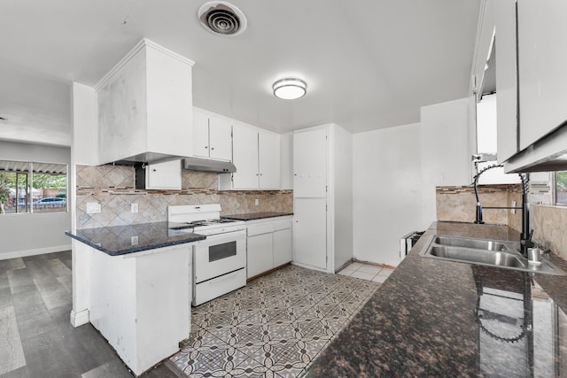 kitchen featuring white gas stove, decorative backsplash, a peninsula, white cabinetry, and visible vents