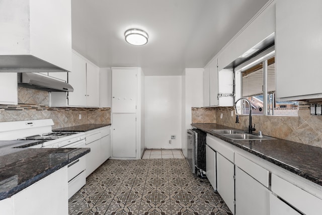 kitchen with a sink, decorative backsplash, white cabinets, under cabinet range hood, and white range with gas cooktop