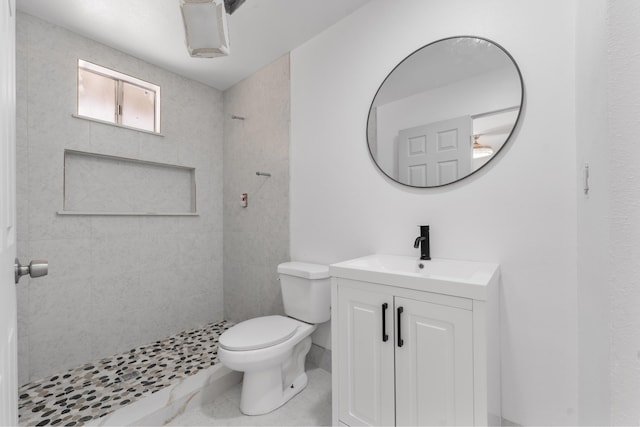 full bathroom with toilet, vanity, and tiled shower