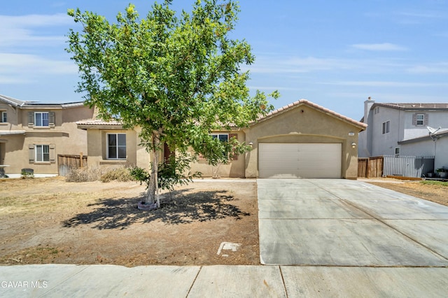 2407 Bavarian Ave, Rosamond, CA 93560 - view of front of home featuring stucco siding, an attached garage, driveway, and a tile roof