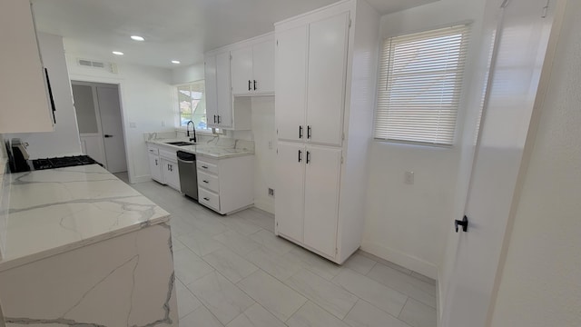 kitchen with dishwasher, light stone counters, gas stove, and white cabinetry