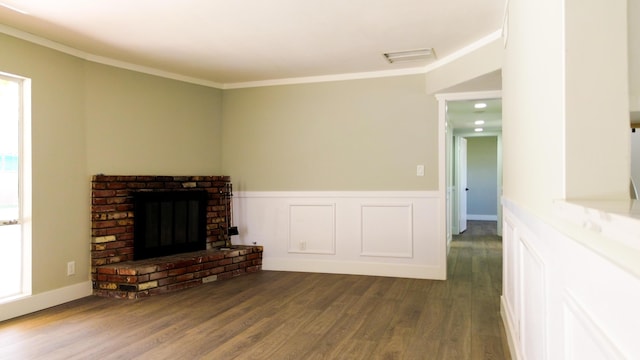 living area with visible vents, dark wood finished floors, a wainscoted wall, ornamental molding, and a brick fireplace