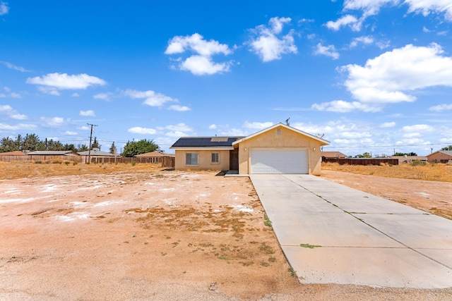 single story home featuring solar panels and a garage