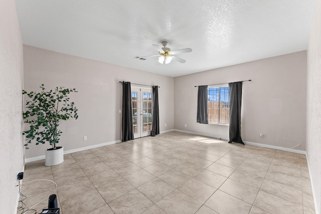 spare room with ceiling fan, light tile patterned flooring, and a textured ceiling