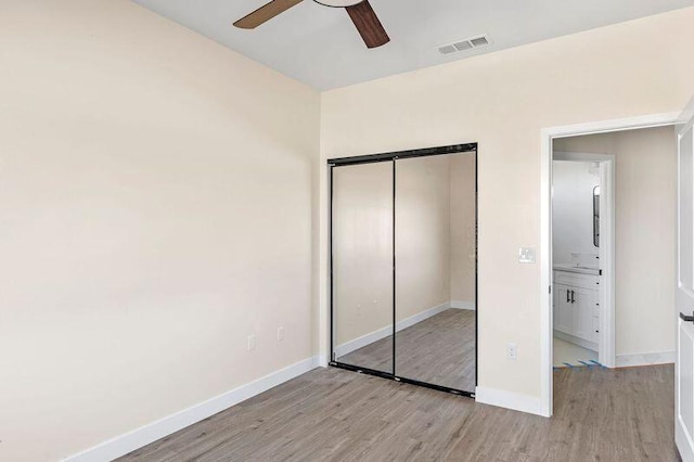 unfurnished bedroom featuring ceiling fan, light wood-type flooring, and a closet