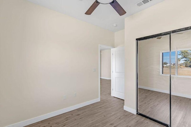 unfurnished bedroom featuring ceiling fan, a closet, and light hardwood / wood-style floors