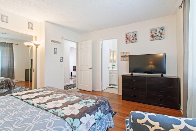 44605 Gillan Ave, Lancaster, CA 93535 - bedroom featuring wood finished floors, a textured ceiling, and ensuite bath