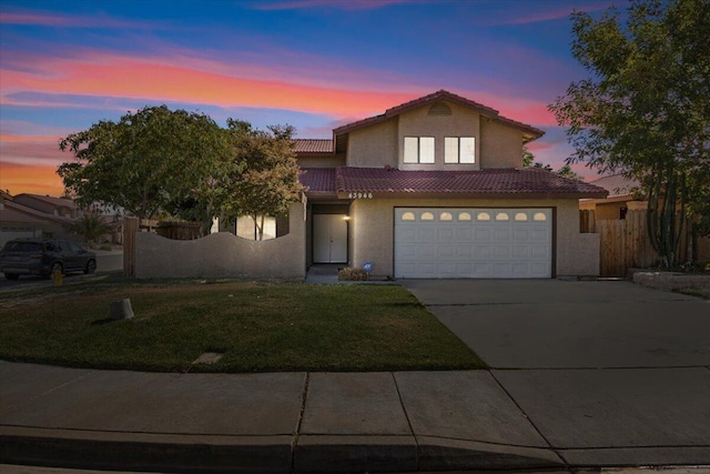 view of front of home with a garage and a yard