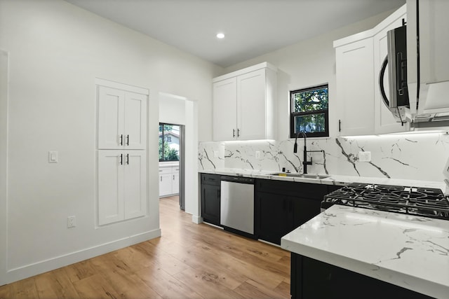 2745 Kenwood Ave, Los Angeles, CA 90007 - kitchen featuring appliances with stainless steel finishes, a sink, white cabinetry, and a healthy amount of sunlight