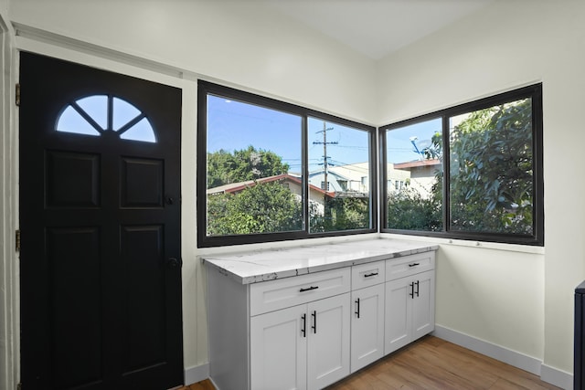 2745 Kenwood Ave, Los Angeles, CA 90007 - interior space with baseboards, light stone counters, white cabinetry, and light wood-style floors