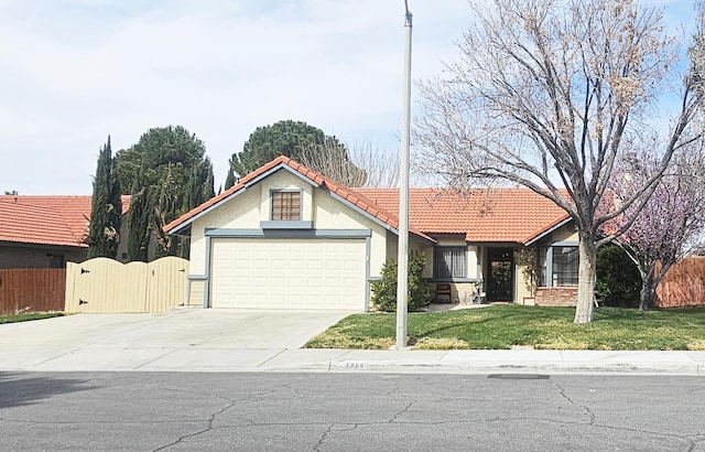 view of front of home with a gate, an attached garage, concrete driveway, a front lawn, and a tile roof