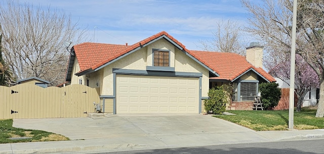 view of front of property with a gate, an attached garage, stucco siding, concrete driveway, and a tiled roof