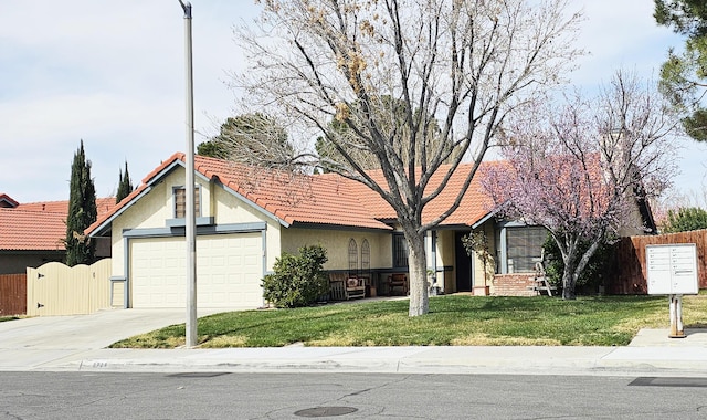 view of front of property featuring a front lawn, fence, a tiled roof, concrete driveway, and stucco siding