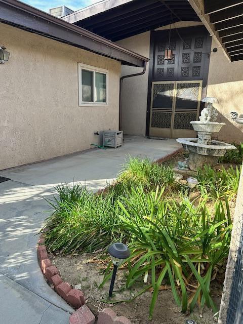 doorway to property featuring a patio area and stucco siding