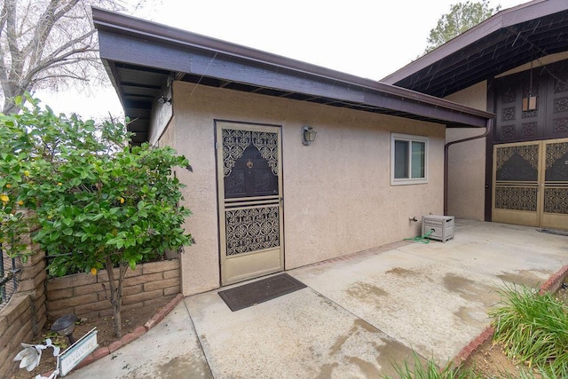 property entrance featuring a patio area and stucco siding