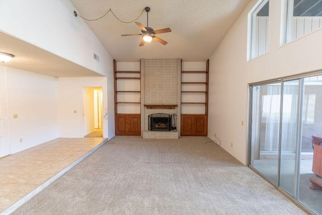 unfurnished living room featuring high vaulted ceiling, a brick fireplace, light colored carpet, and a textured ceiling