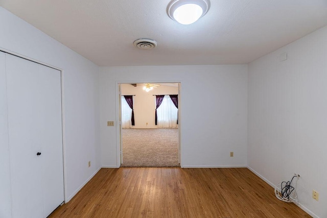 unfurnished room with visible vents, baseboards, and wood finished floors