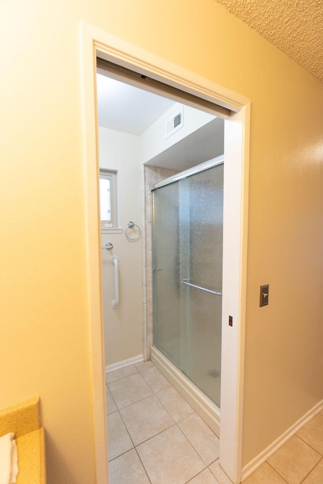 bathroom with baseboards, a stall shower, visible vents, and tile patterned floors