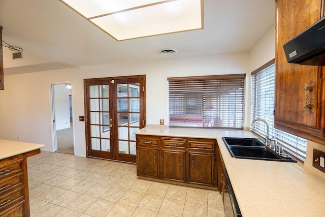 kitchen with light countertops, ventilation hood, a sink, and french doors