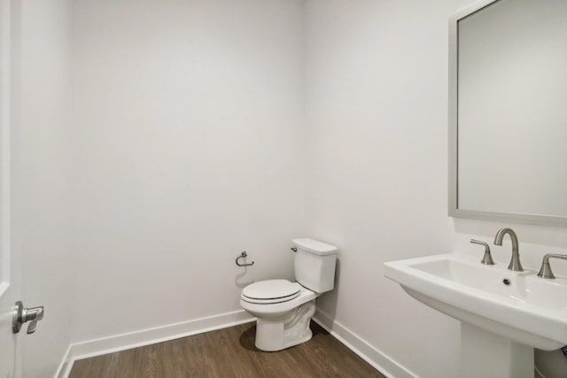 bathroom with hardwood / wood-style floors, toilet, and sink