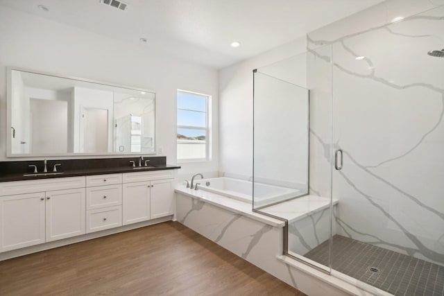 bathroom featuring vanity, wood-type flooring, and shower with separate bathtub