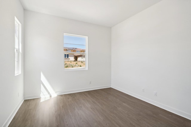 empty room with dark hardwood / wood-style flooring