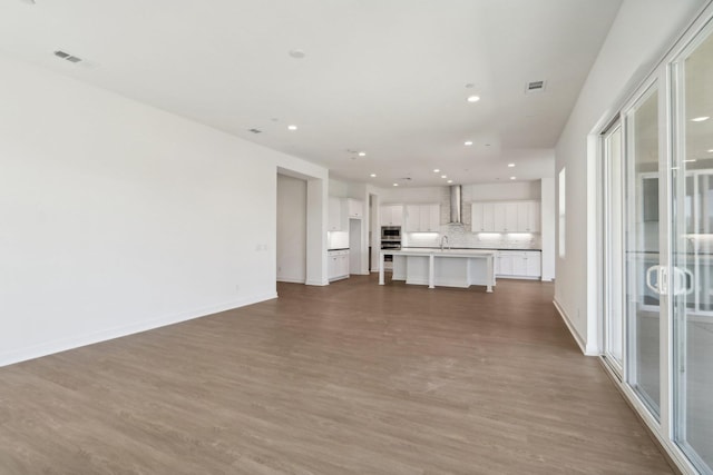 unfurnished living room featuring sink and wood-type flooring