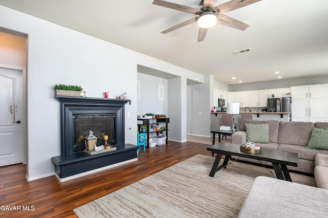 44927 Normandy Ln, Lancaster, CA 93536 - living room featuring dark wood-style floors, a ceiling fan, a glass covered fireplace, and recessed lighting