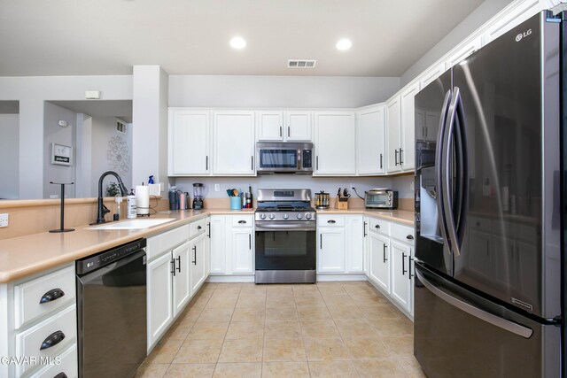 44927 Normandy Ln, Lancaster, CA 93536 - kitchen with stainless steel appliances, white cabinets, light tile patterned floors, light countertops, and recessed lighting