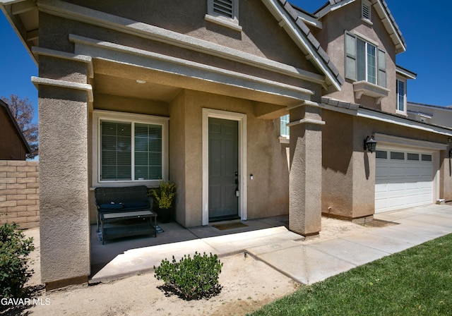44927 Normandy Ln, Lancaster, CA 93536 - view of exterior entry featuring an attached garage and stucco siding