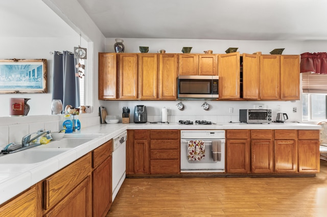 kitchen featuring white appliances, light hardwood / wood-style flooring, and sink