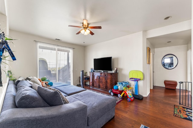 living room featuring ceiling fan and dark wood-type flooring