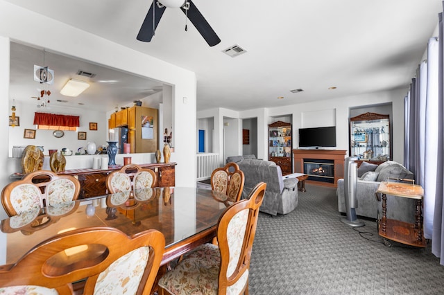 carpeted dining space with ceiling fan