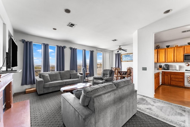 carpeted living room with ceiling fan