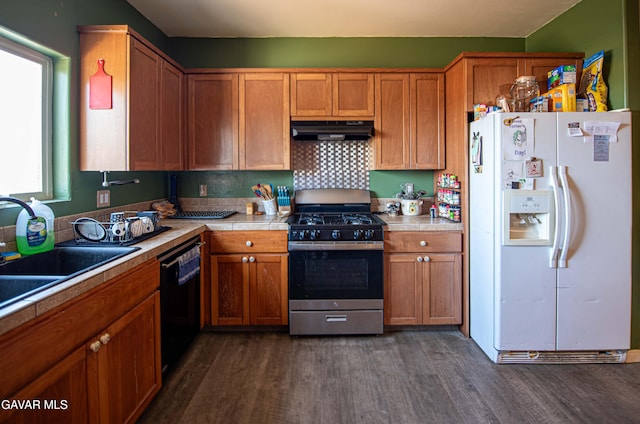 8801 Lupine Loop Dr, California City, CA 93505 - kitchen with white refrigerator with ice dispenser, stainless steel gas stove, under cabinet range hood, black dishwasher, and dark wood-style floors