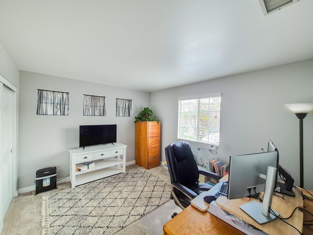 home office with light carpet, visible vents, and baseboards