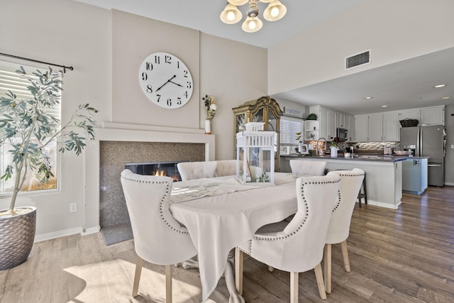 dining area featuring hardwood / wood-style flooring and an inviting chandelier