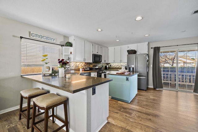 kitchen featuring white cabinets, appliances with stainless steel finishes, tasteful backsplash, sink, and dark hardwood / wood-style floors