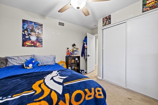 bedroom featuring ceiling fan, light colored carpet, and a closet