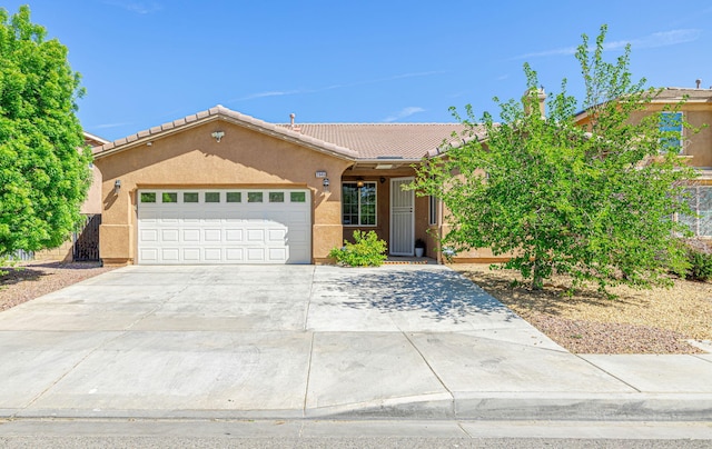 2645 E Nugent St, Lancaster, CA 93535 - ranch-style house with a tile roof, an attached garage, concrete driveway, and stucco siding