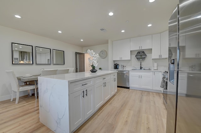 12871 W Osborne St, Arleta, CA 91331 - kitchen with appliances with stainless steel finishes, a kitchen island, light wood-style flooring, recessed lighting, and white cabinets