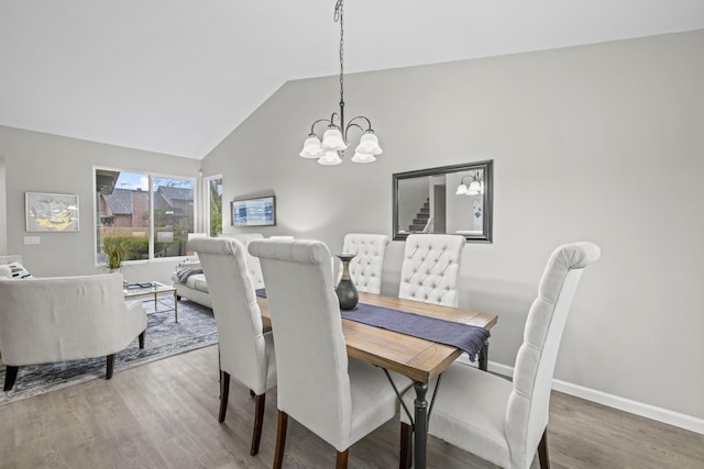 dining room with vaulted ceiling, an inviting chandelier, and hardwood / wood-style floors