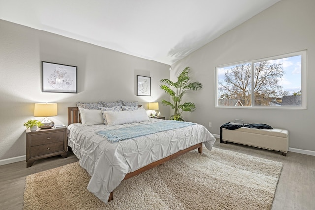 bedroom featuring hardwood / wood-style flooring and vaulted ceiling