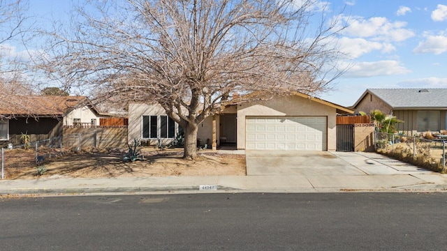 view of front facade with a garage, concrete driveway, fence, and stucco siding