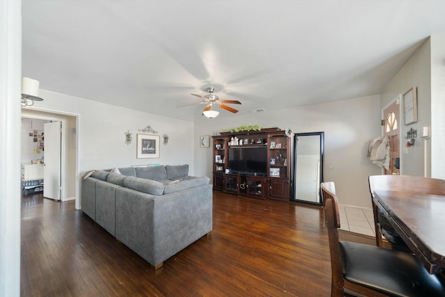 living room with ceiling fan and dark wood-type flooring