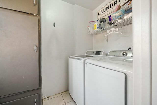 laundry room featuring washer and clothes dryer and light tile patterned floors